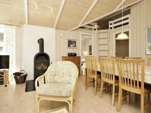 uma sala de jantar com uma mesa e cadeiras e uma lareira em 10 person holiday home in lb k em Ålbæk