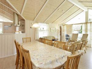 uma sala de jantar com mesa e cadeiras em 10 person holiday home in lb k em Ålbæk