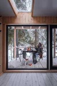 a person sitting at a table in a house with a dog at Greenvald Park Scandinavia in Ogon'ki