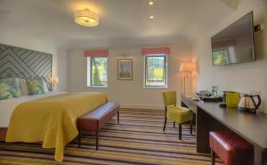 a hotel room with a bed and a desk at Denbies Vineyard Hotel in Dorking