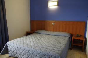 a bedroom with a bed and a blue wall at Hotel San Martino in Cassibile