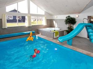 uma criança numa piscina com um escorrega aquático em 16 person holiday home in Sydals em Høruphav