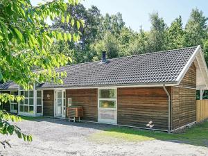 a log cabin with a porch and a chair at 10 person holiday home in Hasle in Hasle