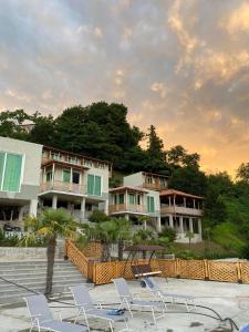 a group of buildings with lawn chairs and trees at Green Hills Batumi in Batumi