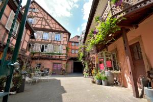 an alley in an old building with tables and chairs at CHEZ CECILE Bed and Breakfast chez le VIGNERON in Colmar