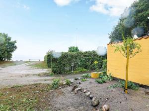 uma pequena árvore ao lado de uma parede amarela em 4 person holiday home in Nyk bing M em Refshammer