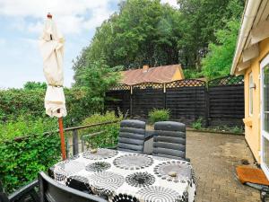 un ombrellone e un tavolo con sedie su un patio di 4 person holiday home in Nyk bing M a Refshammer