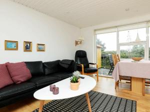 - un salon avec un canapé noir et une table dans l'établissement 4 person holiday home in Nyk bing M, à Refshammer