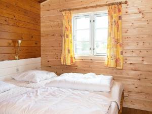 een slaapkamer met 2 bedden voor een raam bij 6 person holiday home in R m in Lakolk