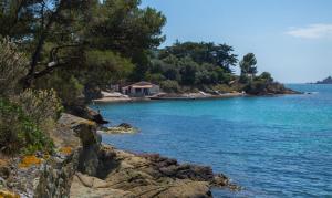 a body of water with a house on the shore at AGAY le pti bonheur 60m2 rez de jardin, en bord de mer in Saint-Raphaël