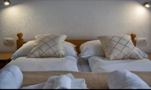 two beds with white sheets and pillows in a bedroom at Apartment Josipa in Seliste Dreznicko