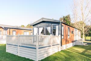 a house with a white fence and a gazebo at Ebor Lodge With Hot Tub in Pocklington