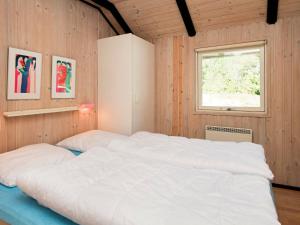 a large white bed in a room with a window at 8 person holiday home in R m in Kongsmark