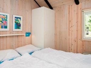 a bedroom with two beds and a cabinet at 8 person holiday home in R m in Kongsmark