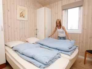 een vrouw die op een groot bed staat bij 5 person holiday home in L kken in Løkken