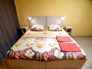 アルハンゲリスクにあるYanemezStayのベッドルーム1室(花柄のベッドカバー、枕付)