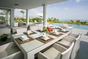 a dining room with a table and chairs and a pool at Villa Dolphin Saint Martin in Orient Bay