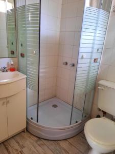 Un baño con ducha, inodoro y lavabo. en Pinamar Centro Departamentos NO GRUPOS DE JOVENES, en Pinamar