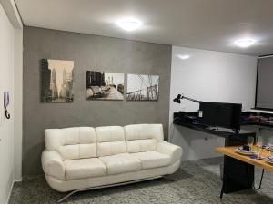 a living room with a white couch and a table at Locking's Lourdes 1 in Belo Horizonte