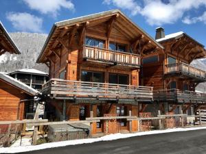 una gran casa de madera con una terraza envolvente en K Terra 4, en Montriond