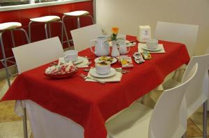 a table with a red table cloth with food on it at Hotel San Martino in Cassibile