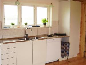 a kitchen with a sink and two windows at 6 person holiday home in R dby in Kramnitse