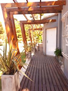 una pérgola de madera con plantas en una casa en Pinamar Centro Departamentos NO GRUPOS DE JOVENES, en Pinamar