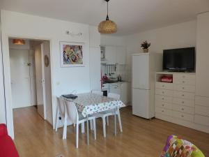 a kitchen with a table and chairs and a refrigerator at Appartement Pour 4 Personnes Avec Vue Sur Le Port De Plaisance- Residence Le Genois in Capbreton