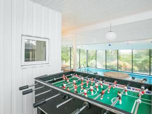 a ping pong table in a room with a pool at 8 person holiday home in Fars in Ertebølle