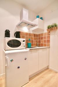 a kitchen with a microwave and a refrigerator at Au coeur de Sanary-sur-Mer studio cosy in Sanary-sur-Mer