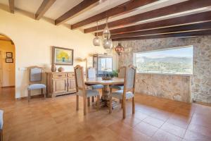 d'une salle à manger avec une table, des chaises et une fenêtre. dans l'établissement Pou dels Escarabats, à Pollença