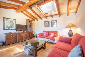 sala de estar con muebles de color rojo y TV de pantalla plana en Pou dels Escarabats, en Pollensa