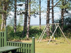 a swing set in a park with a bench at 5 person holiday home in R m in Rømø Kirkeby