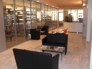 a library with chairs and a table in a room at HéberGement du POD in La Chaux-de-Fonds