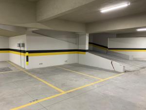 an empty parking garage with yellow and black stripes at Locking's Lourdes 1 in Belo Horizonte