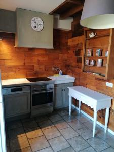uma cozinha com um fogão, um lavatório e um relógio em Cépage de la Tourelle em Ways
