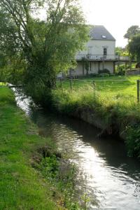 een rivier met een huis op de achtergrond bij Cépage de la Tourelle in Ways