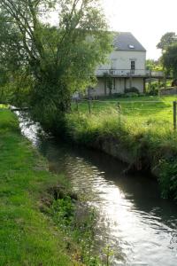 ein Fluss mit einem Haus im Hintergrund in der Unterkunft Cépage de la Tourelle in Ways