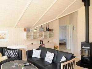 sala de estar con muebles de cuero negro y chimenea en 7 person holiday home in Ulfborg, en Sønder Nissum