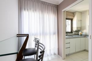 a kitchen with a chair in front of a window at AT Suites in Córdoba
