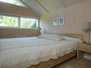 a bedroom with a large bed and a window at Three-Bedroom Holiday home in Væggerløse 11 in Marielyst