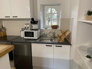 a kitchen with a sink and a microwave at Gîte de Boutissaint, au cœur du Parc in Treigny