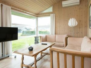 Sjølundにある6 person holiday home in Sj lundのリビングルーム(ソファ、テーブル、テレビ付)