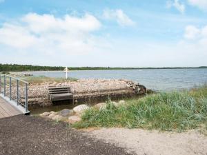 eine Person, die auf einem Pier neben einem Wasserkörper steht in der Unterkunft 6 person holiday home in Juelsminde in Juelsminde