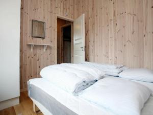 two white beds in a room with wooden walls at Seaside Retreat in Lolland - By Traum Ferienwohnungen in Dannemare