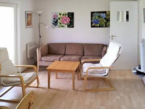 アリンエにある4 person holiday home in Allingeのリビングルーム(ソファ、椅子2脚、テーブル付)