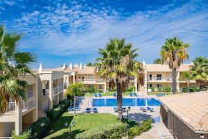 uma vista aérea de um resort com uma piscina e palmeiras em Family Holiday Apartment - Centrally Located - Vale de Parra em Albufeira