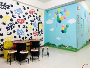 a room with two stools and a wall with balloons at Art Ocean B&B in Yujing