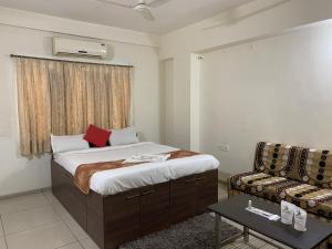 a bedroom with a bed and a couch in a room at Hotel JK Lions - Koradi Road Nagpur in Nagpur +64 photos