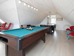 a room with a pool table and two tables at 21 person holiday home in Bl vand in Blåvand